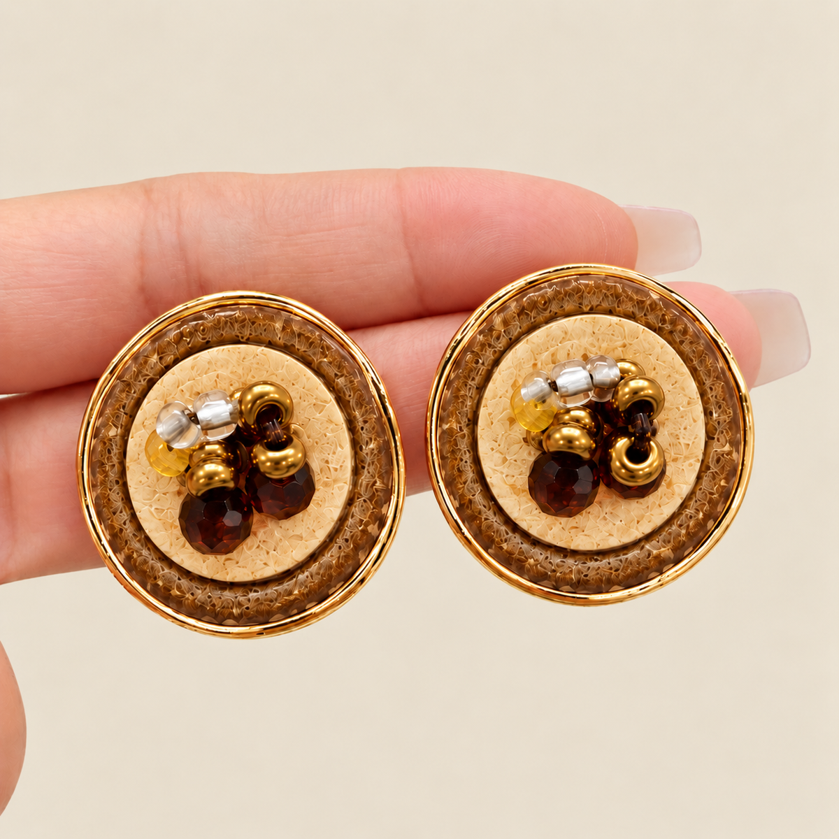 Hand-held detail of brown beaded round stud earrings