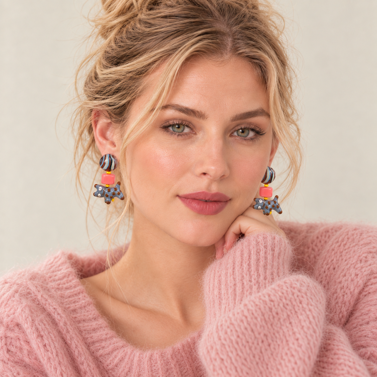 Model wearing colorful dog drop stud earrings