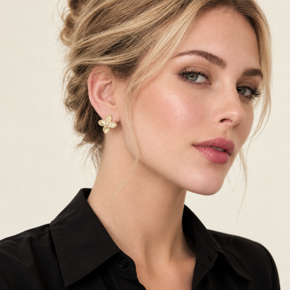 Model wearing gold-tone four-petal flower stud earrings