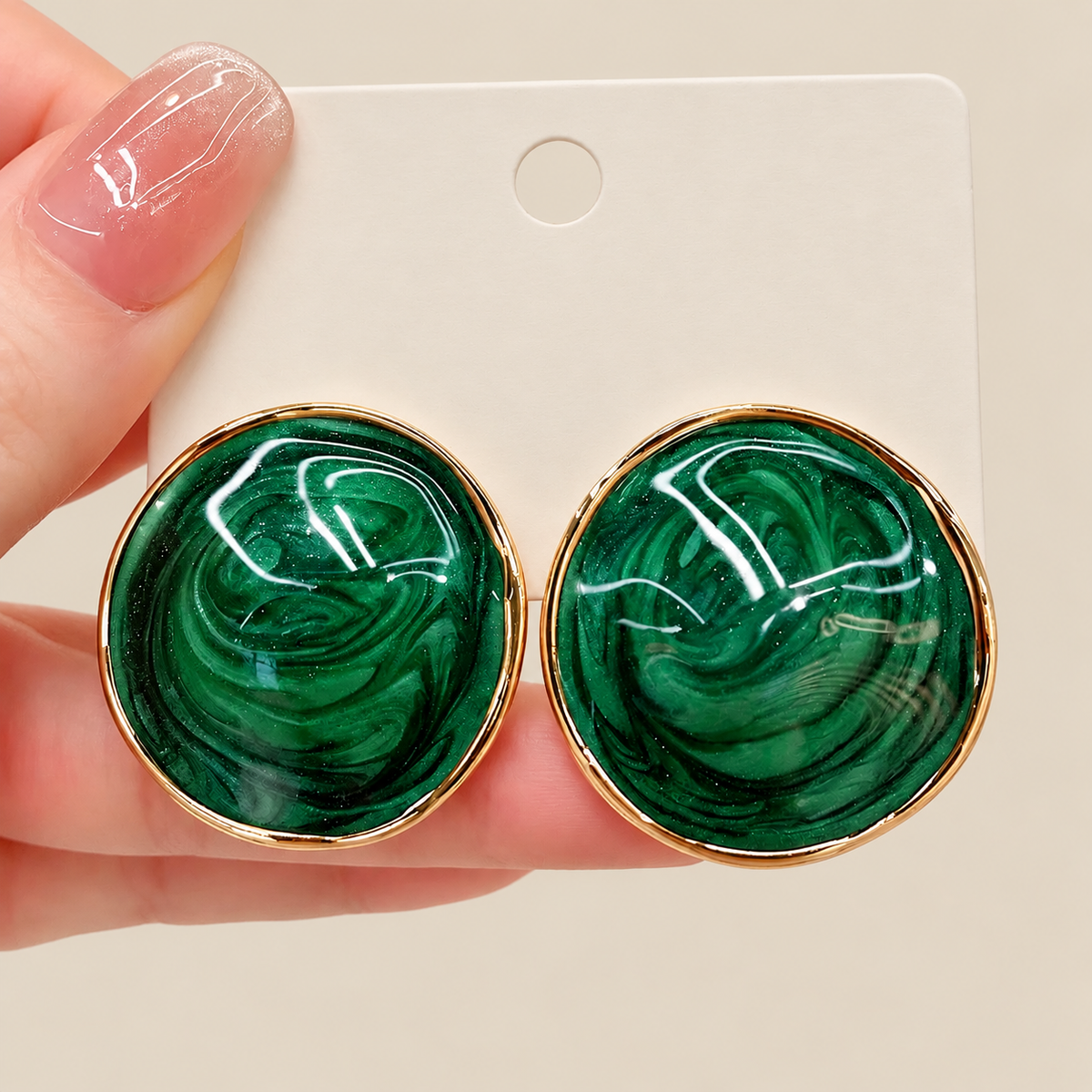 Green marbled round stud earrings shown in hand