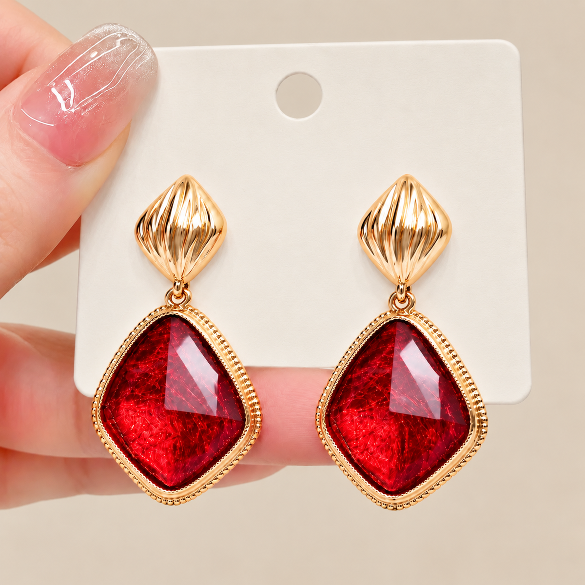 Red imitation gemstone drop earrings displayed on jewelry card